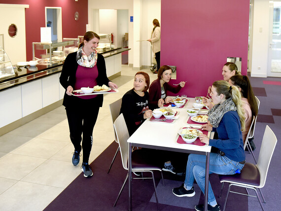 Eine Gruppe Mütter beim geselligen Mittagessen im Restaurant des Marianne van den Bosch Hauses.