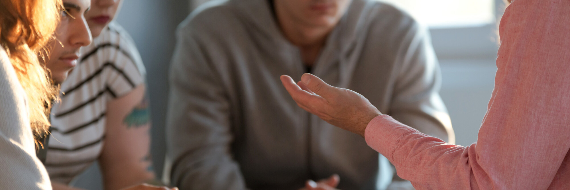 Junge Menschen in einer Therapie- und Gesprächssituation.