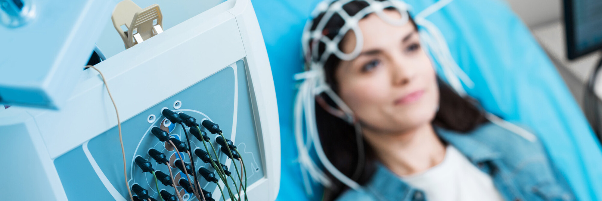 Eine Patientin bei einer EEG-Untersuchung, die elektrische Aktivitäten des Gehirns misst.