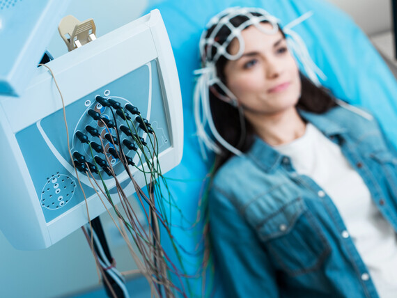 Eine Patientin bei einer EEG-Untersuchung, die elektrische Aktivitäten des Gehirns misst.