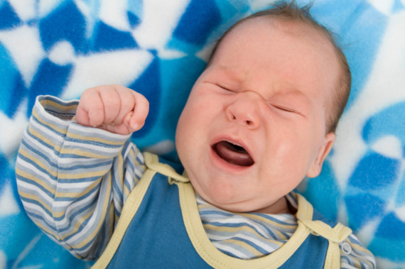 Ein Baby schreit mit geschlossenen Augen.