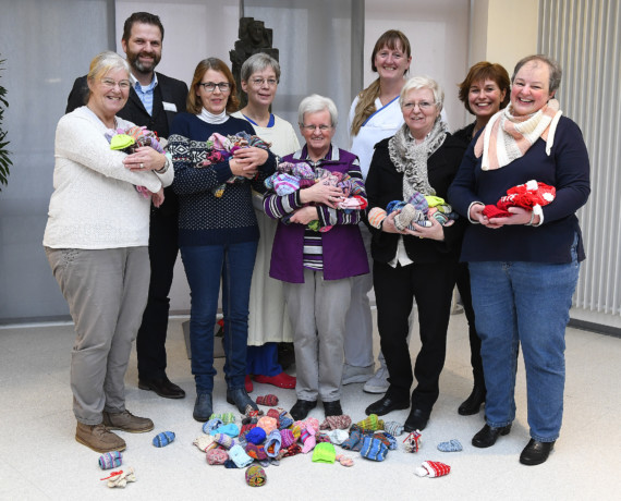 Die Zwergenglück-Strickerinnen Annegret Klamt, Jutta Döllekes, Ursel Wiesner, Elisabeth van Baal und Ulrike Heetlage (vorne v.l.) übergaben dem Team des St.-Antonius-Hospitals reichlich Gestricktes.