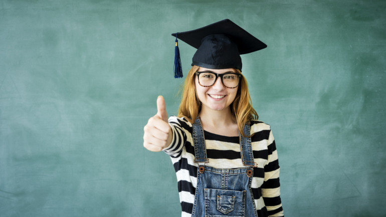 Glückliche Studentin reckt den Daumen.