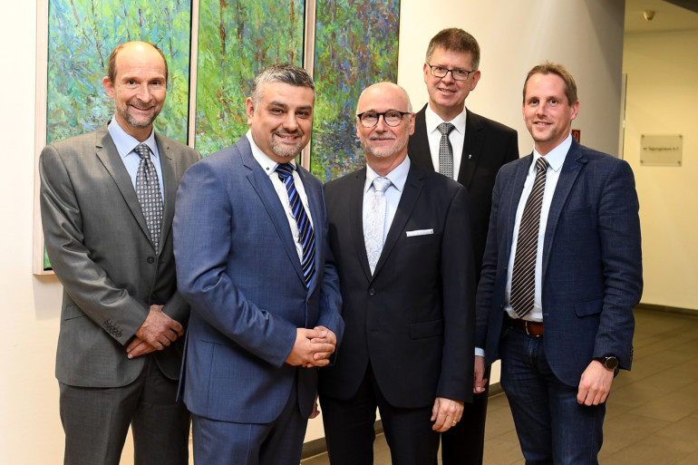 Geschäftsführer Bernd Ebbers begrüßt Dr. Ufuk Gündug per Handschlag. Mit im Bild: Professor Volker Runde, Propst Johannes Mecking und Holger Hagemann.