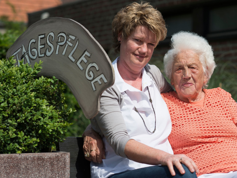Tagespflege im Regina Pacis - Haus für Senioren. Eine Seniorin genießt mit einer Betreuerin die Sonne.